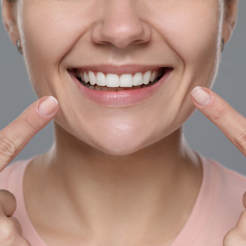 Woman,Showing,Healthy,Gums,On,Gray,Background,,Closeup